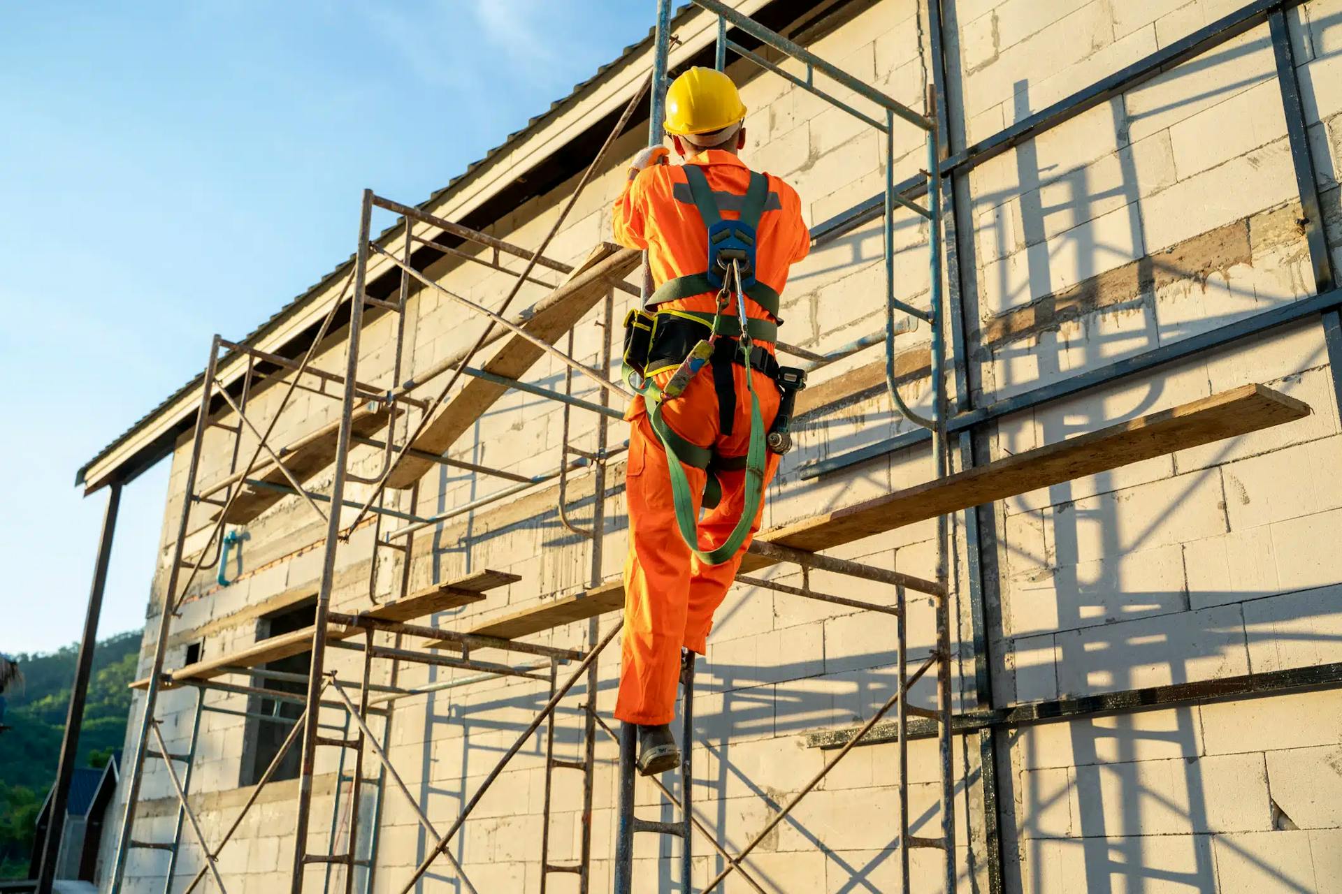 homem trabalhando em andaime suspenso